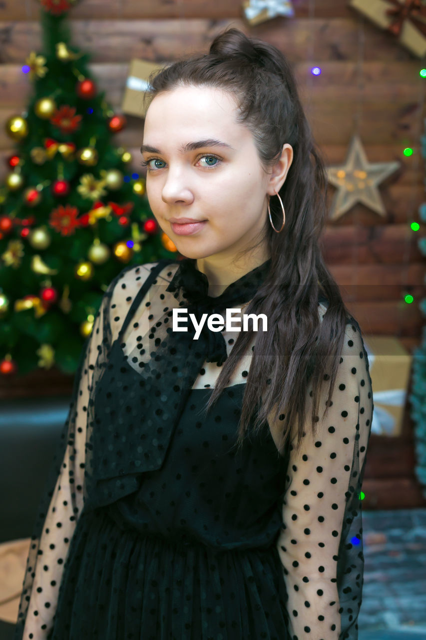 A teenager girl with black hair celebrates christmas her house. person