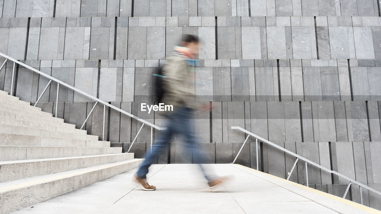 Blurred motion of man walking on staircase