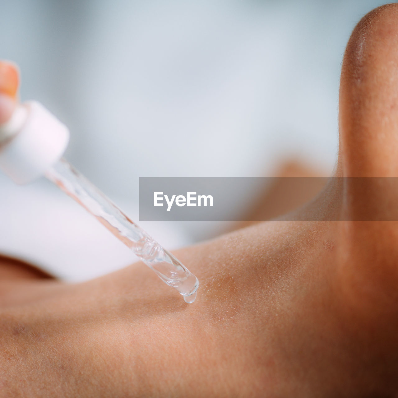 Neck anti-aging treatment. cosmetician applying hyaluronic acid serum on womans neck