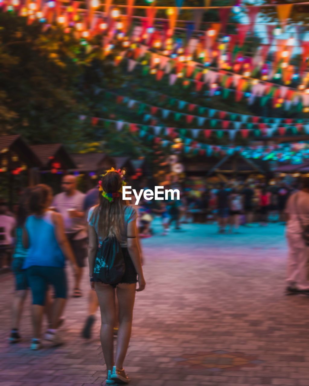 Rear view of women walking on illuminated street