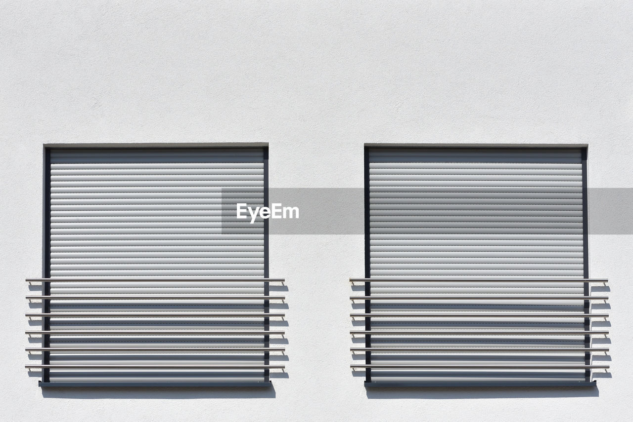Close-up of window roller shutters  on white wall