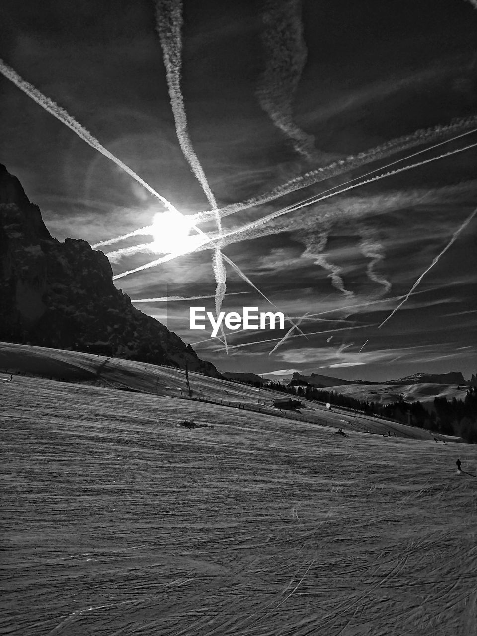LOW ANGLE VIEW OF VAPOR TRAILS IN SKY OVER MOUNTAINS