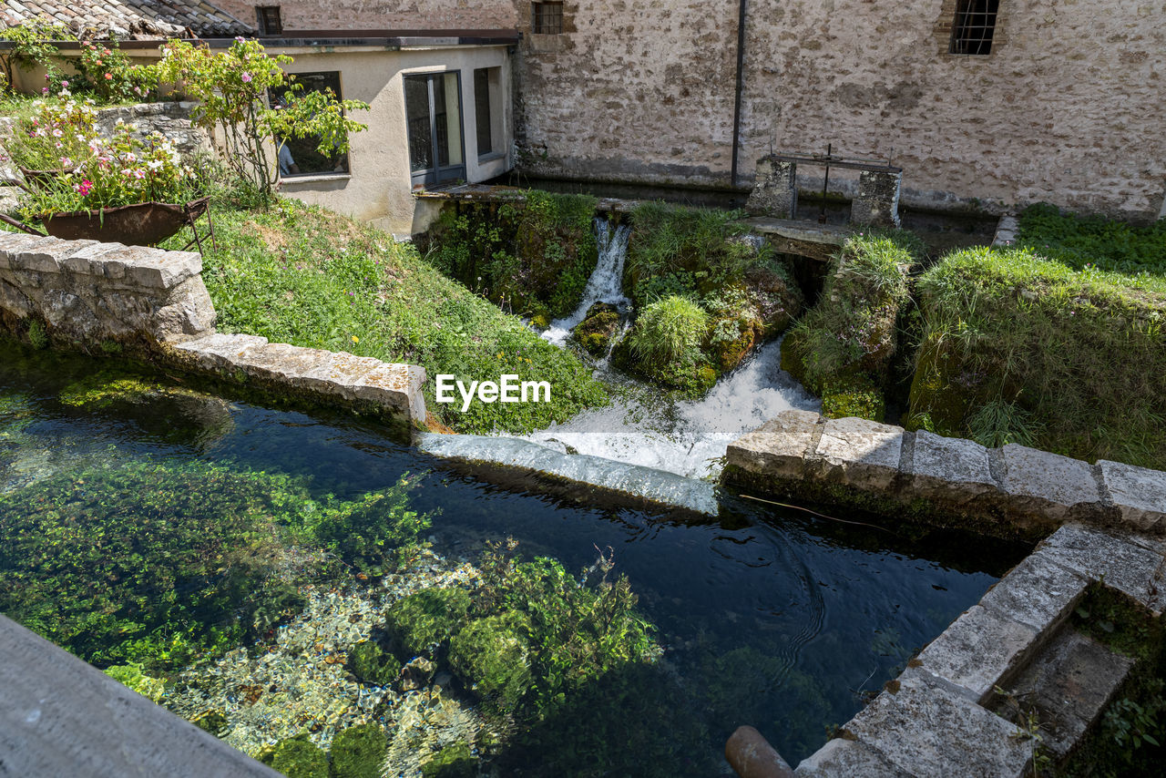 water, architecture, built structure, garden, nature, plant, building exterior, no people, day, wall, backyard, courtyard, estate, building, outdoors, waterway, landscaping, yard, formal garden, high angle view, pond, growth, green, beauty in nature, watercourse, flower, moat