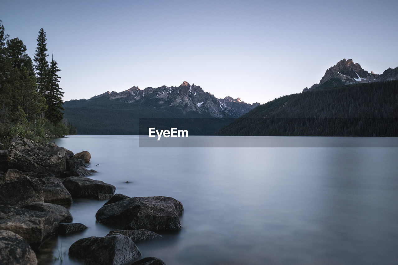 Scenic view of lake and mountains against clear sky