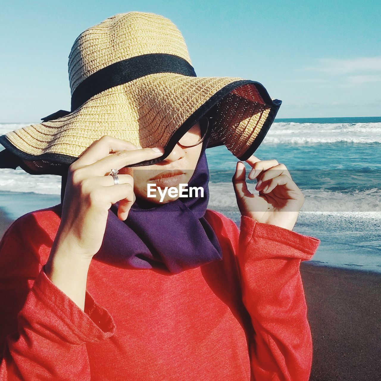 Close-up of young woman wearing hat standing at beach