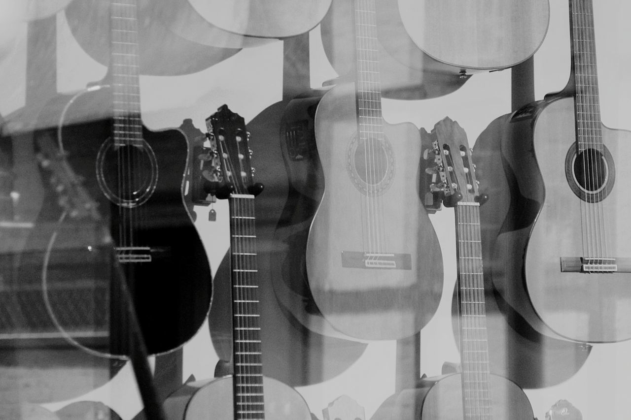 Acoustic guitars for sale in store seen through window