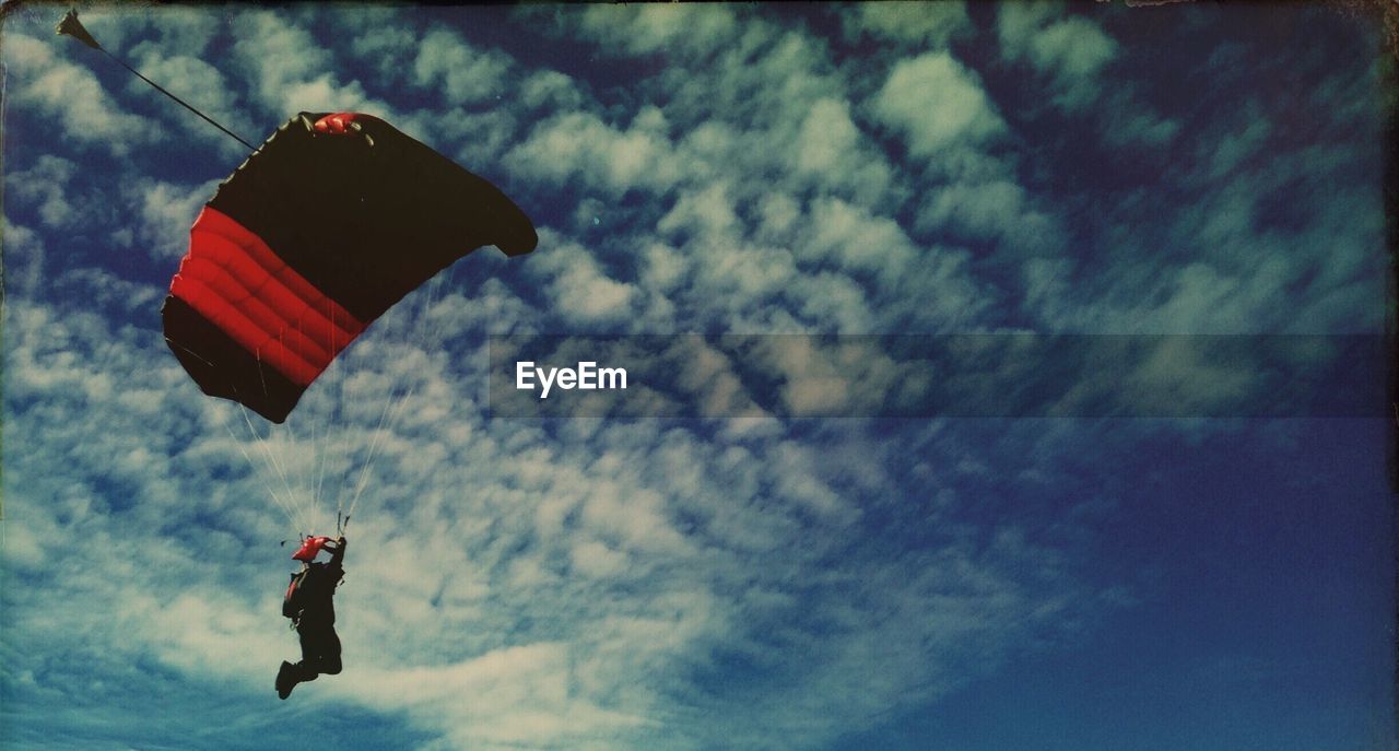 Panoramic view of person paragliding against sky