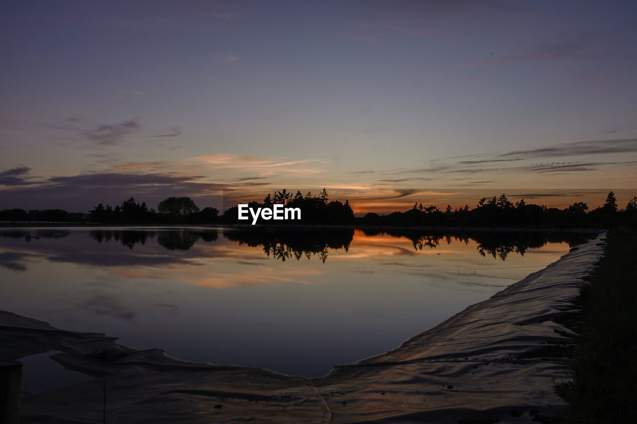 SILHOUETTE TREES BY LAKE AGAINST SKY DURING SUNSET