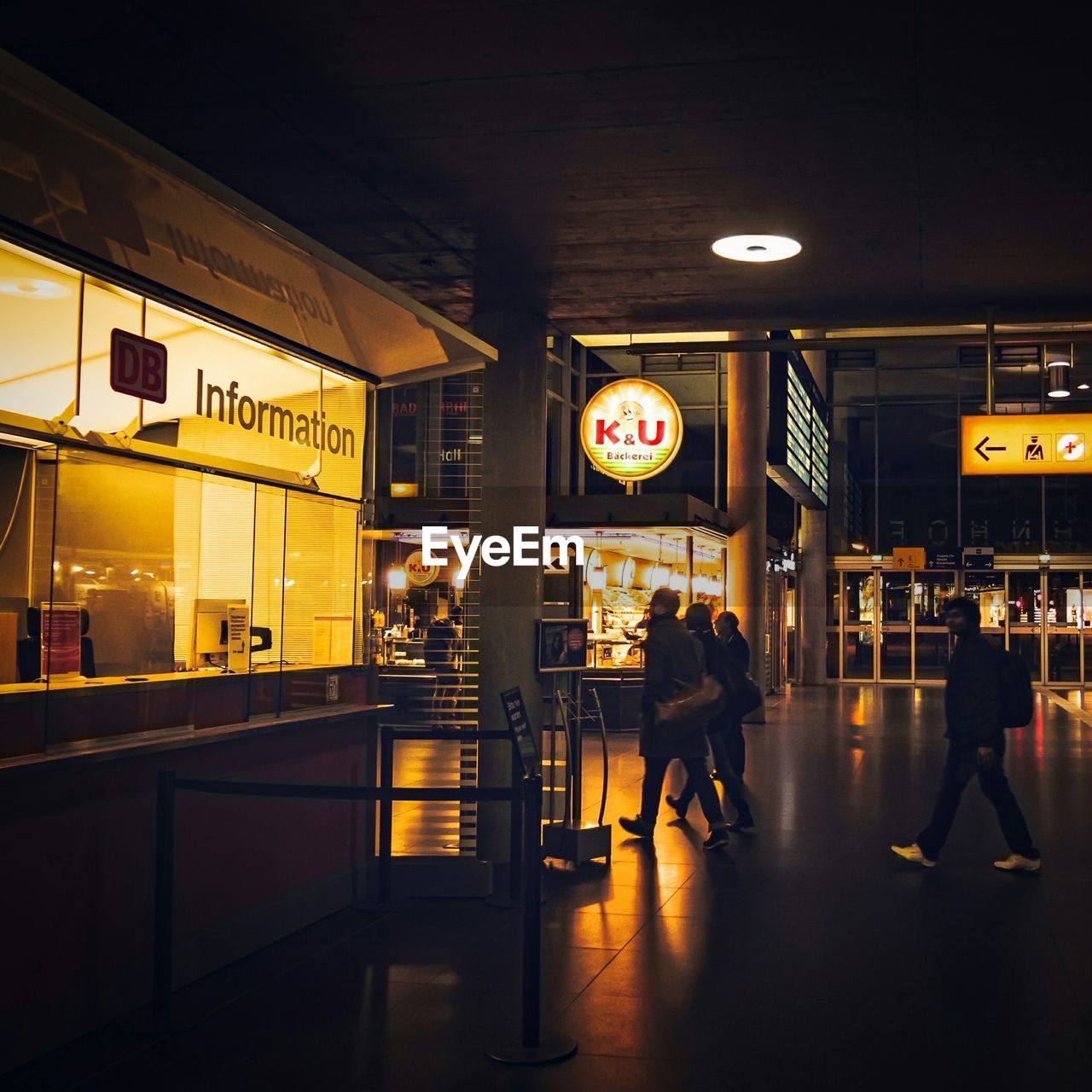 People walking at illuminated airport terminal