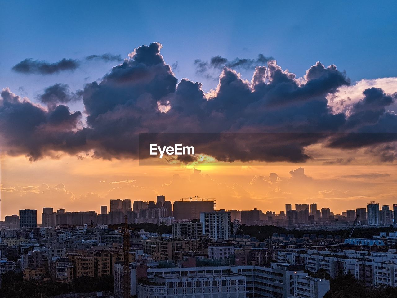 BUILDINGS IN CITY AGAINST CLOUDY SKY