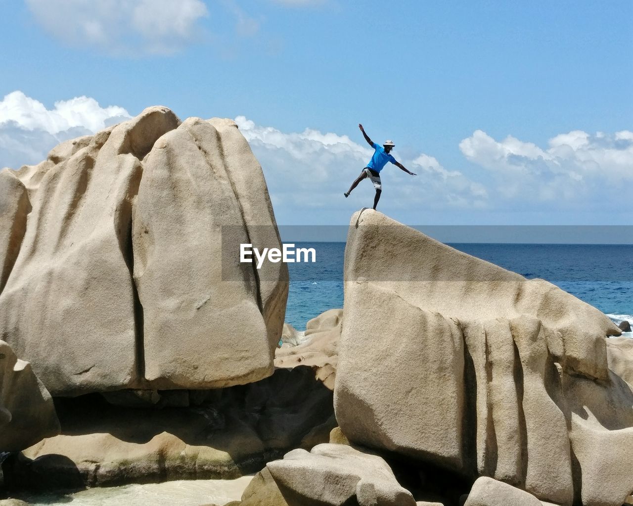 LOW ANGLE VIEW OF MAN BY SEA AGAINST SKY