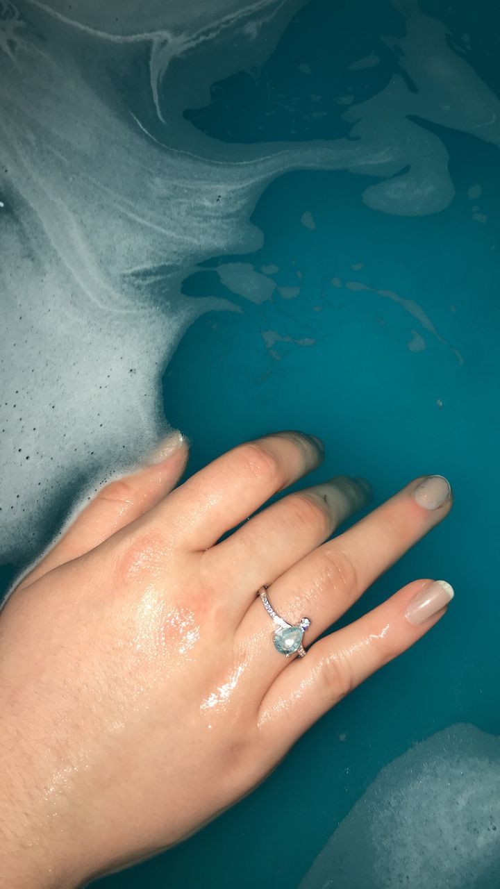 HIGH ANGLE VIEW OF WOMAN FEET ON WATER