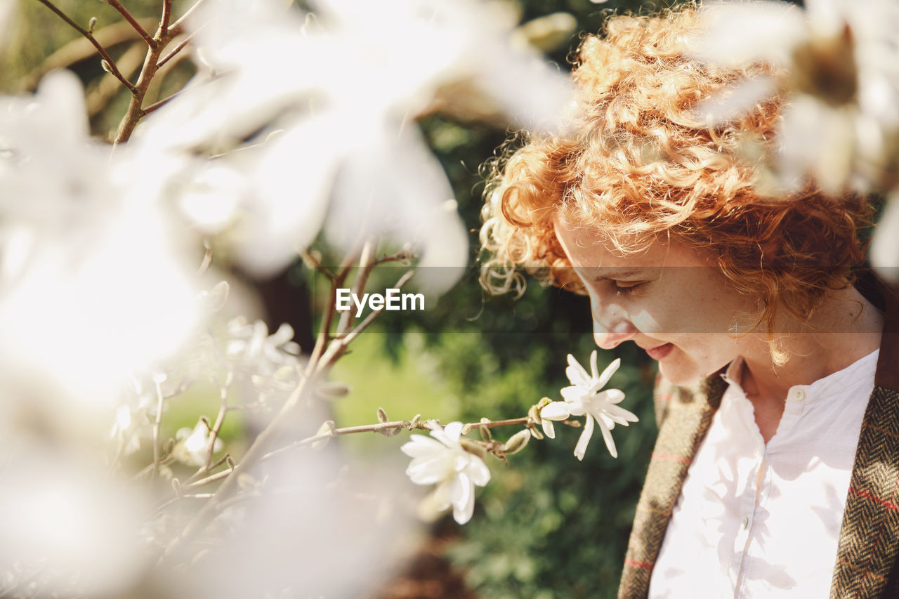 Woman by white flowers in park