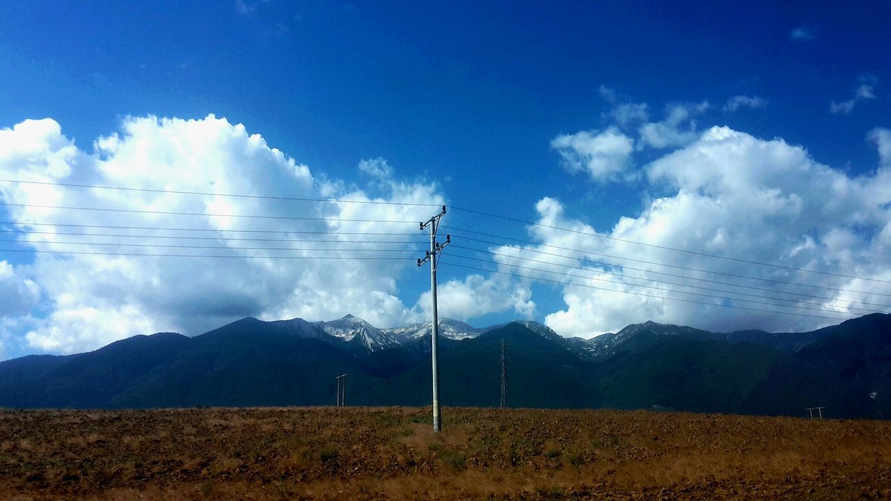 SCENIC VIEW OF MOUNTAINS AGAINST CLOUDY SKY