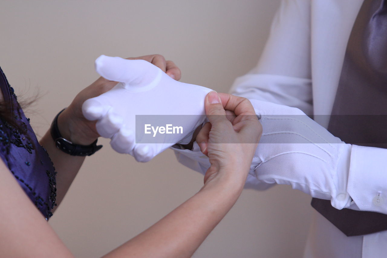 CLOSE-UP OF HANDS HOLDING WHITE BABY