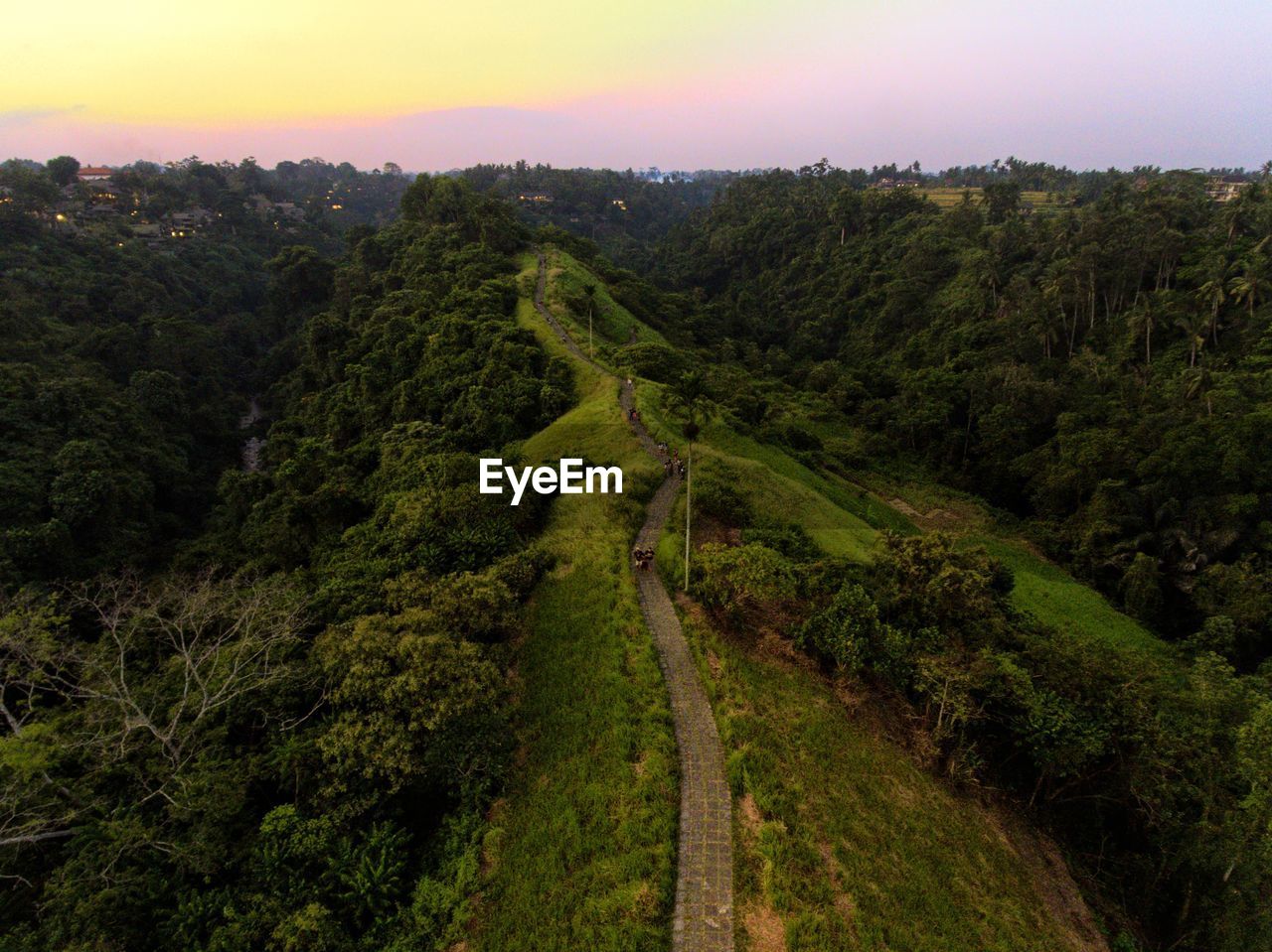 Aerial view of dirt road on mountain against sky during sunset