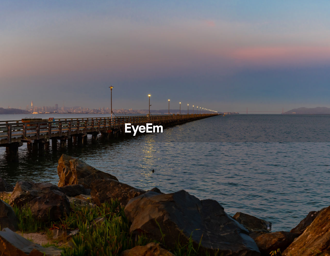 Scenic view of bay against sky at sunset