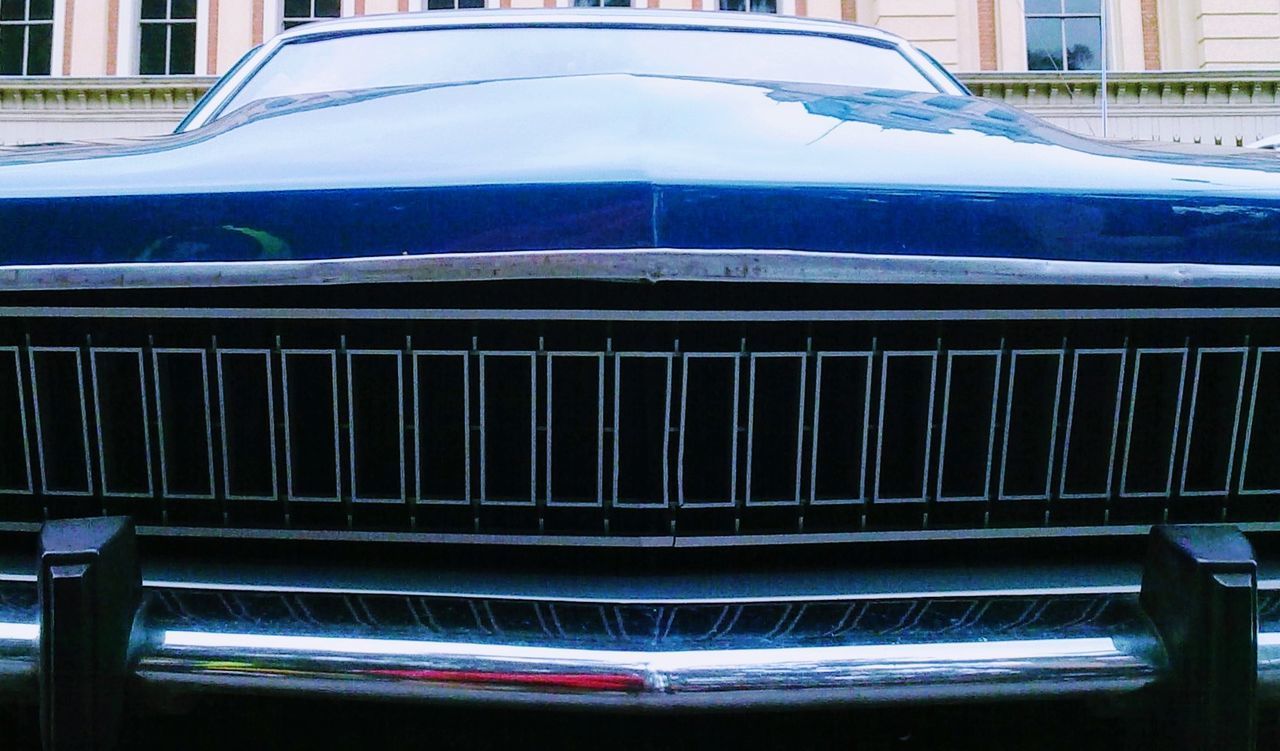 CLOSE-UP OF CAR AGAINST BLUE WALL