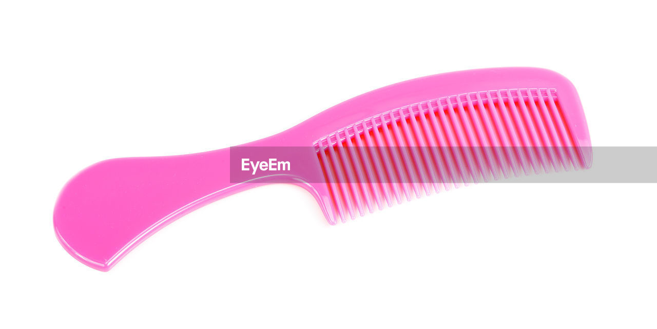 Close-up of pink comb on white background