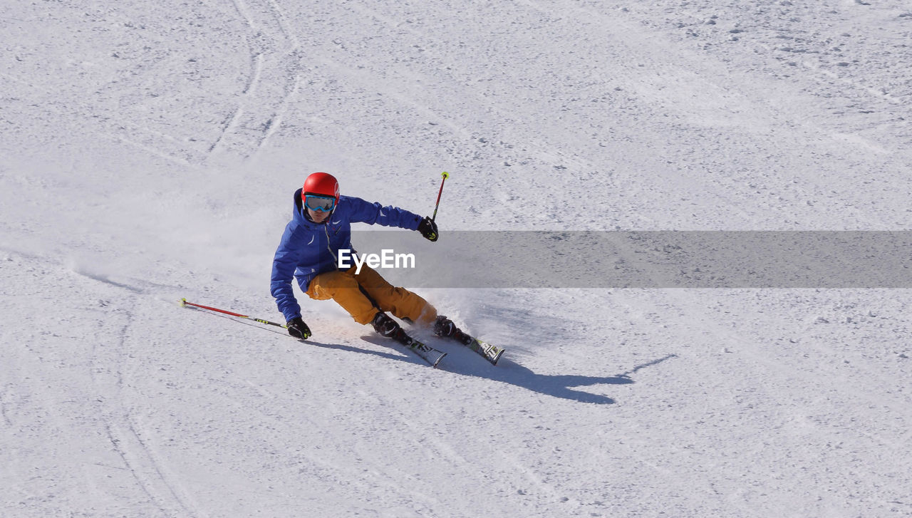 HIGH ANGLE VIEW OF PERSON SKIING ON SNOW COVERED LANDSCAPE