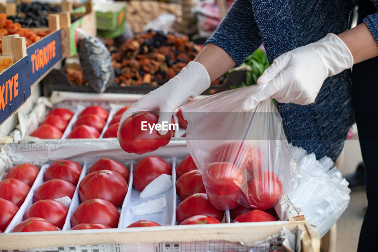 Shopping in the context of a coronavirus pandemic. a woman in disposable gloves buys vegetables