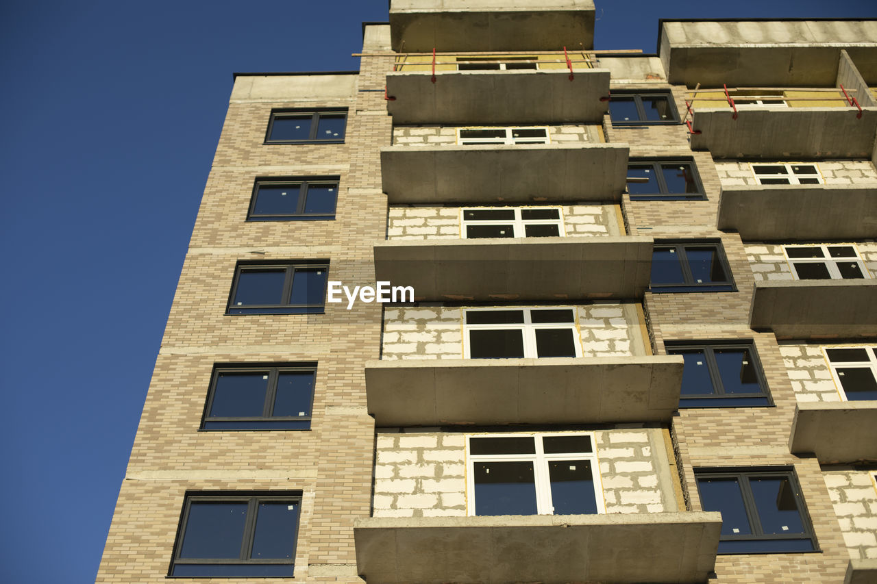 Facade of building. unfinished house. windows in new multi-storey building. 