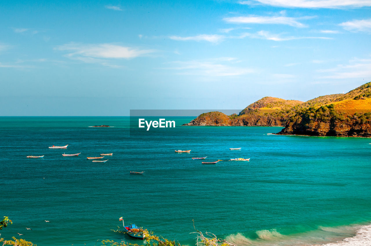 SCENIC VIEW OF SEA BY ROCKS AGAINST SKY