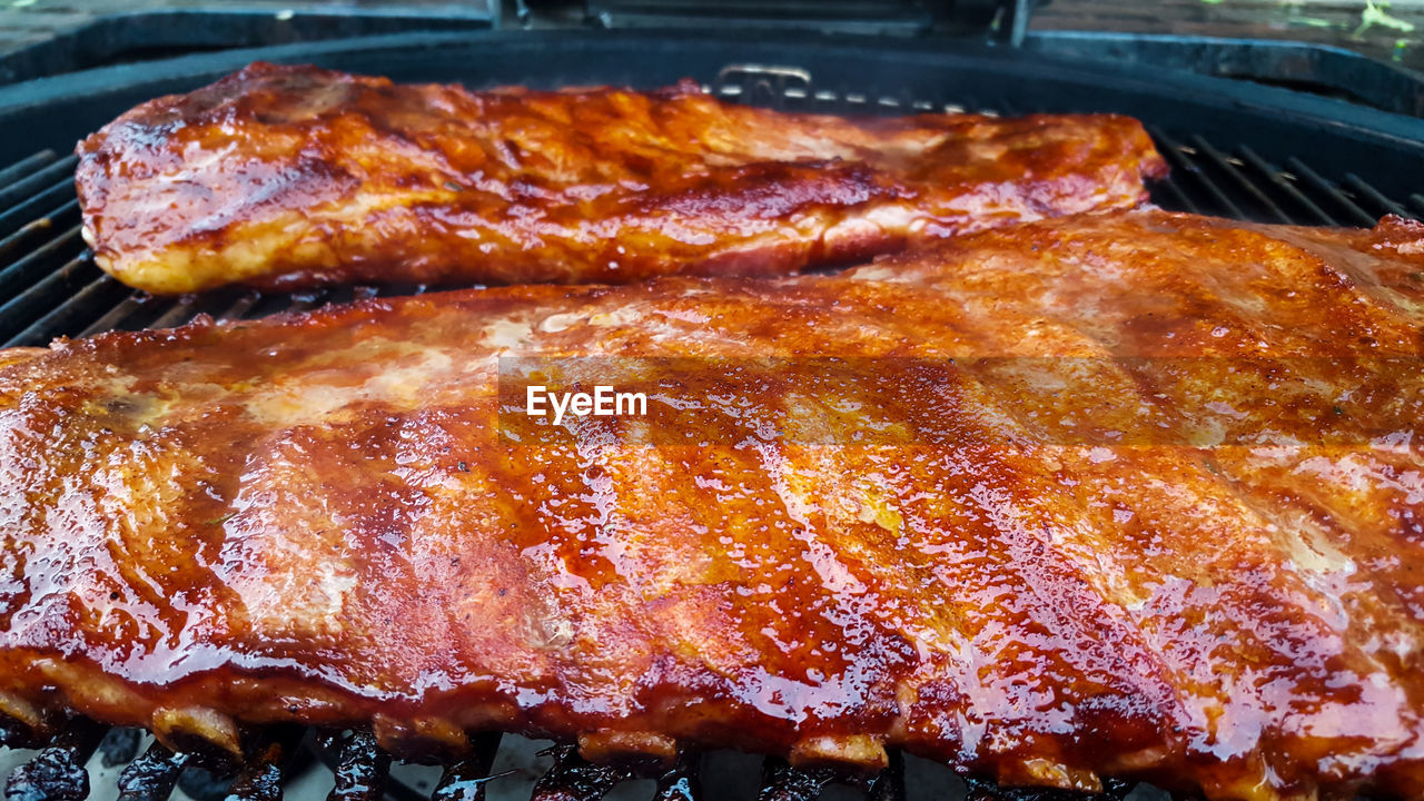 CLOSE-UP OF MEAT COOKING ON BARBECUE