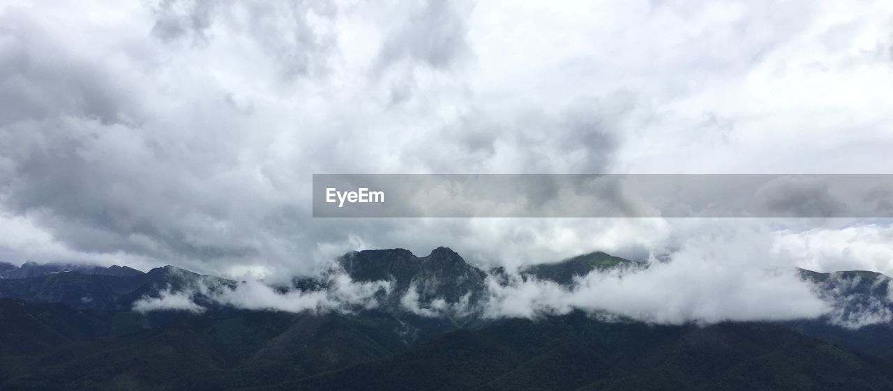 Scenic view of mountains against cloudy sky