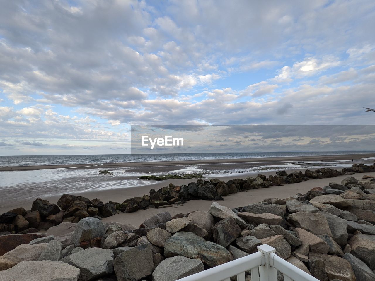 SCENIC VIEW OF ROCKS ON BEACH AGAINST SKY