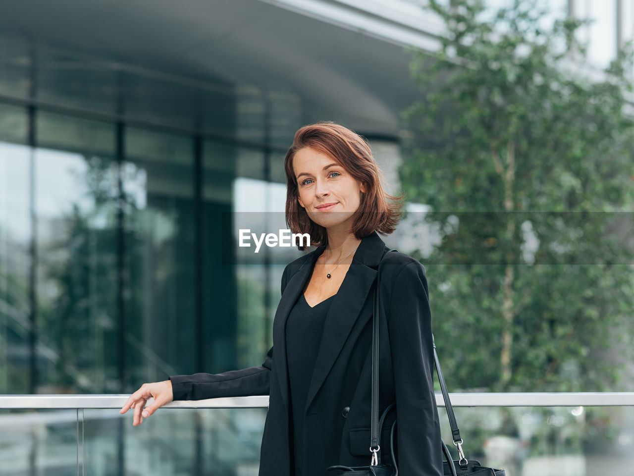 portrait of young woman looking away while standing in city