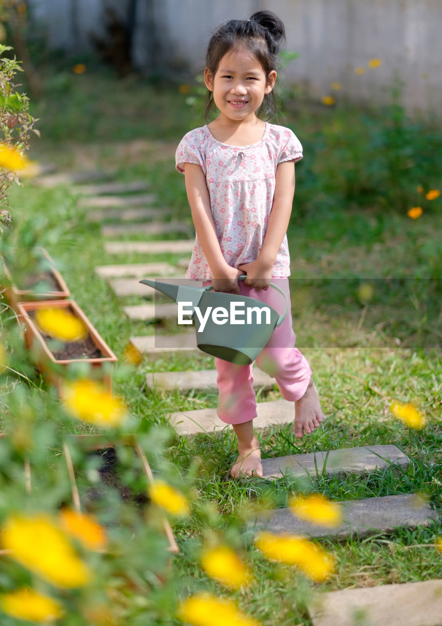 Full length of smiling girl on grass