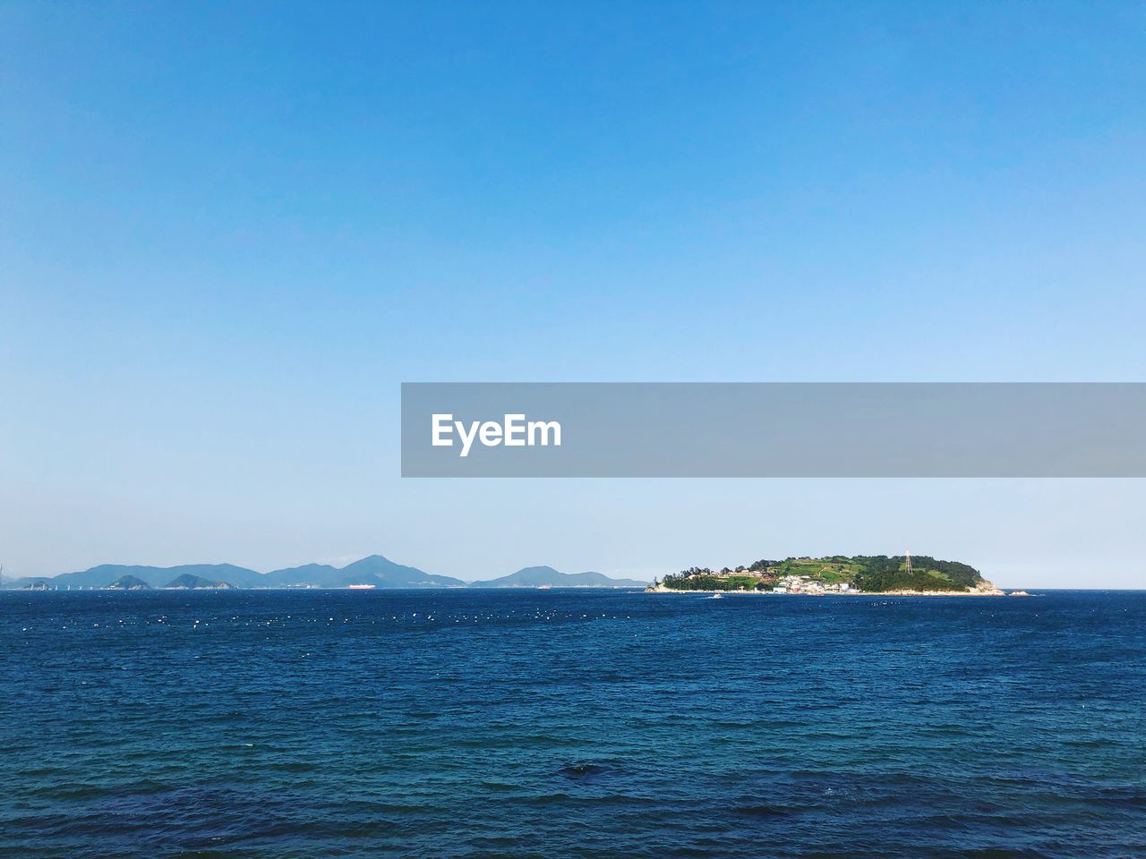 Scenic view of sea against clear blue sky