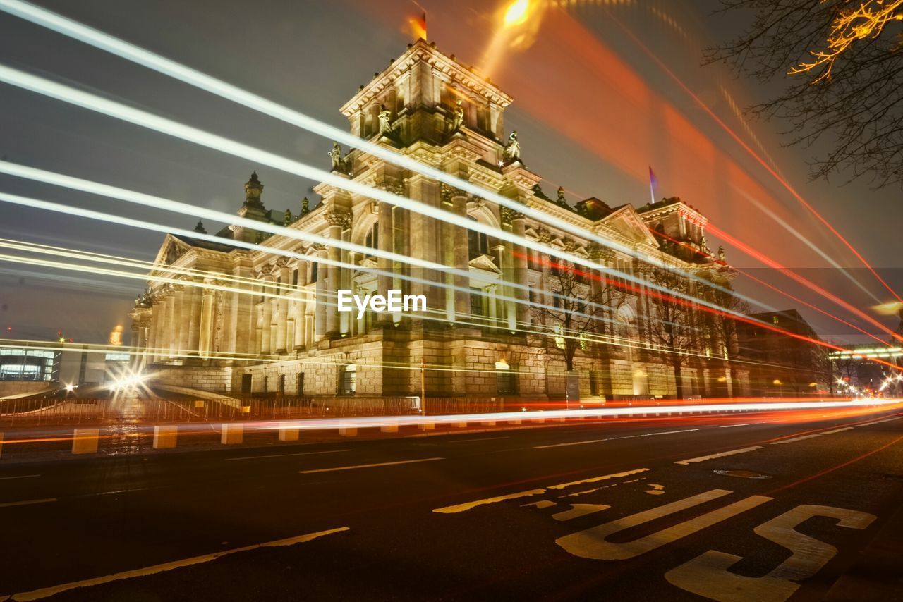 Illuminated light trails on city street against the reichstag