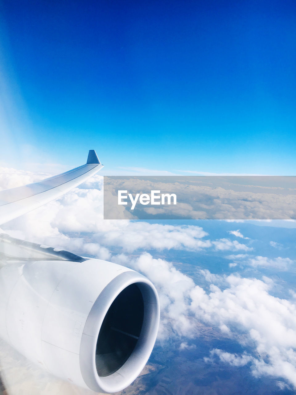 Airplane flying over clouds against blue sky