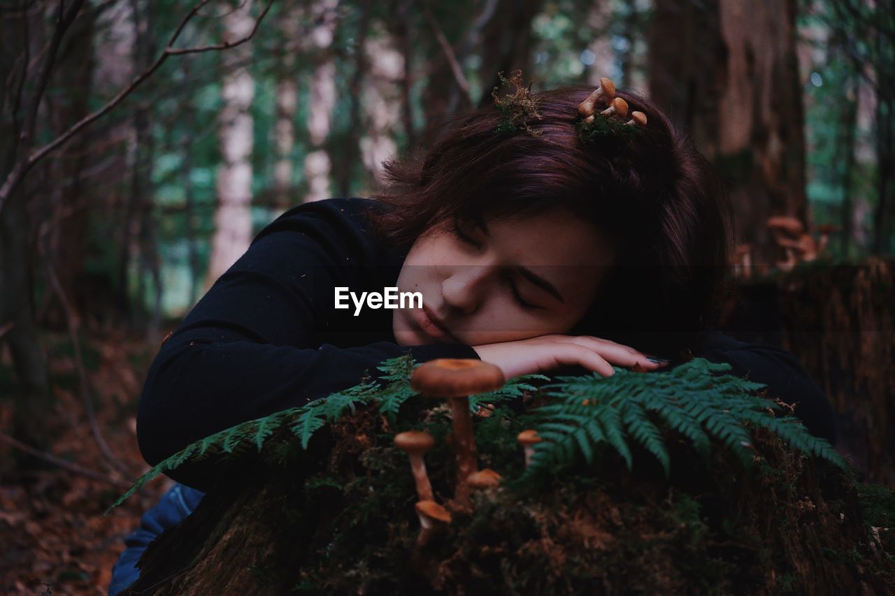 Young woman looking away in forest