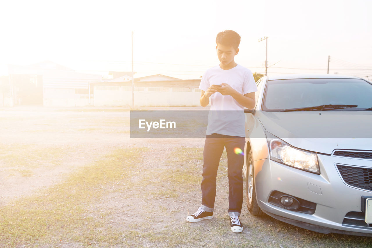 FULL LENGTH PORTRAIT OF A MAN STANDING ON CAR