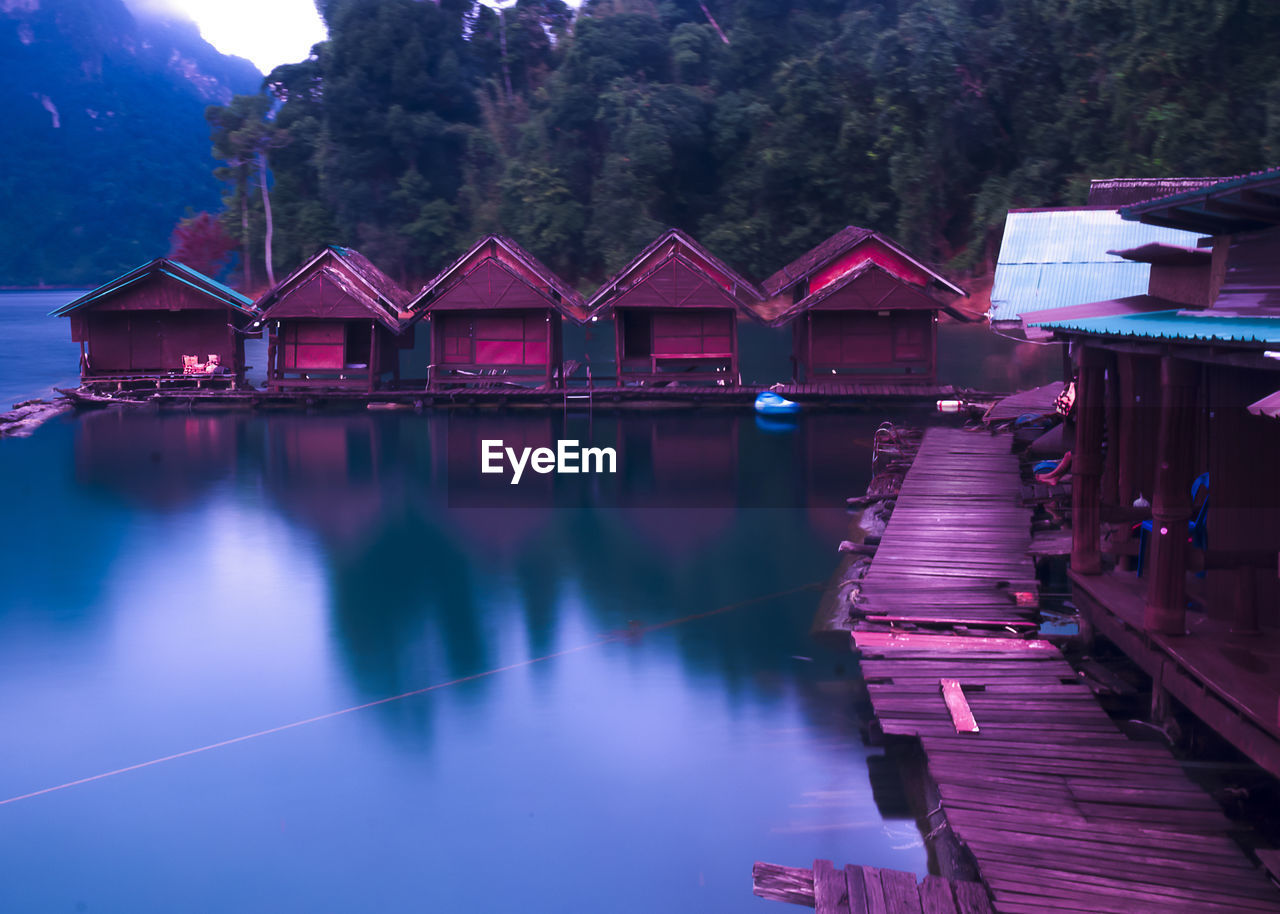 PIER OVER LAKE AMIDST BUILDINGS AGAINST SKY