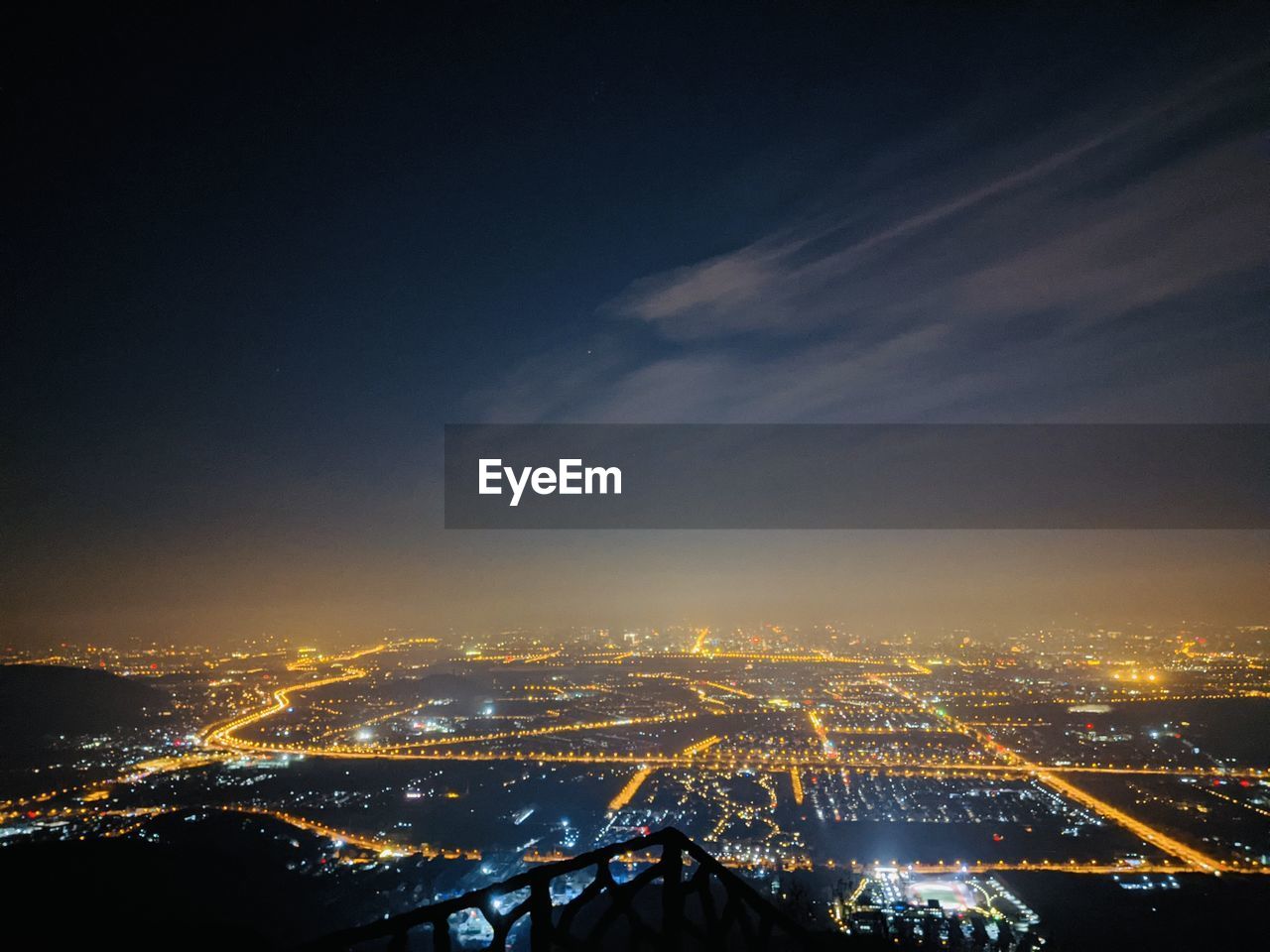 High angle view of illuminated city against sky at night