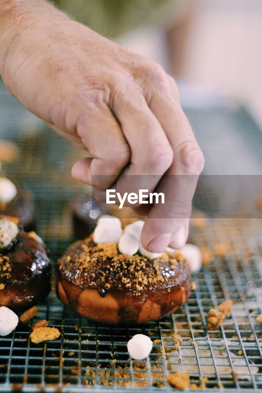 CLOSE-UP OF HAND HOLDING BREAD