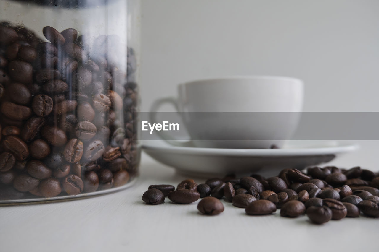 CLOSE-UP OF COFFEE BEANS IN GLASS ON TABLE