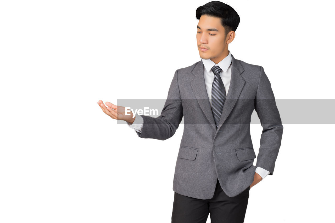 Businessman gesturing against white background