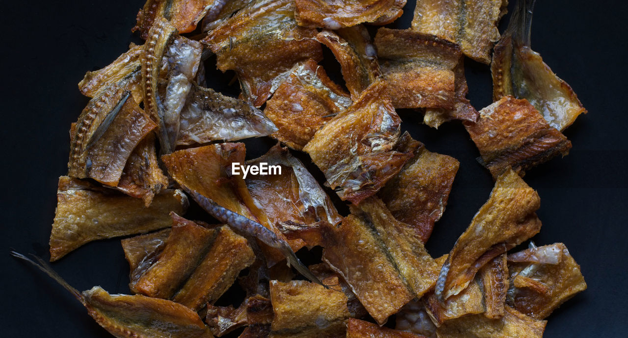 Close-up of dry fishes on black background