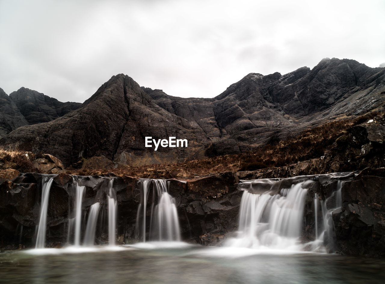 Scenic view of waterfall against sky