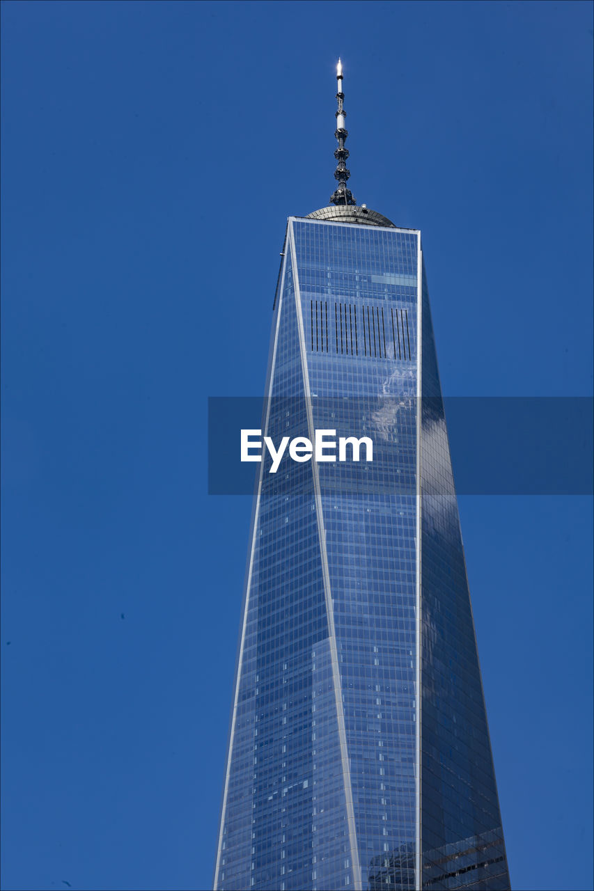 Low angle view of skyscrapers against blue sky