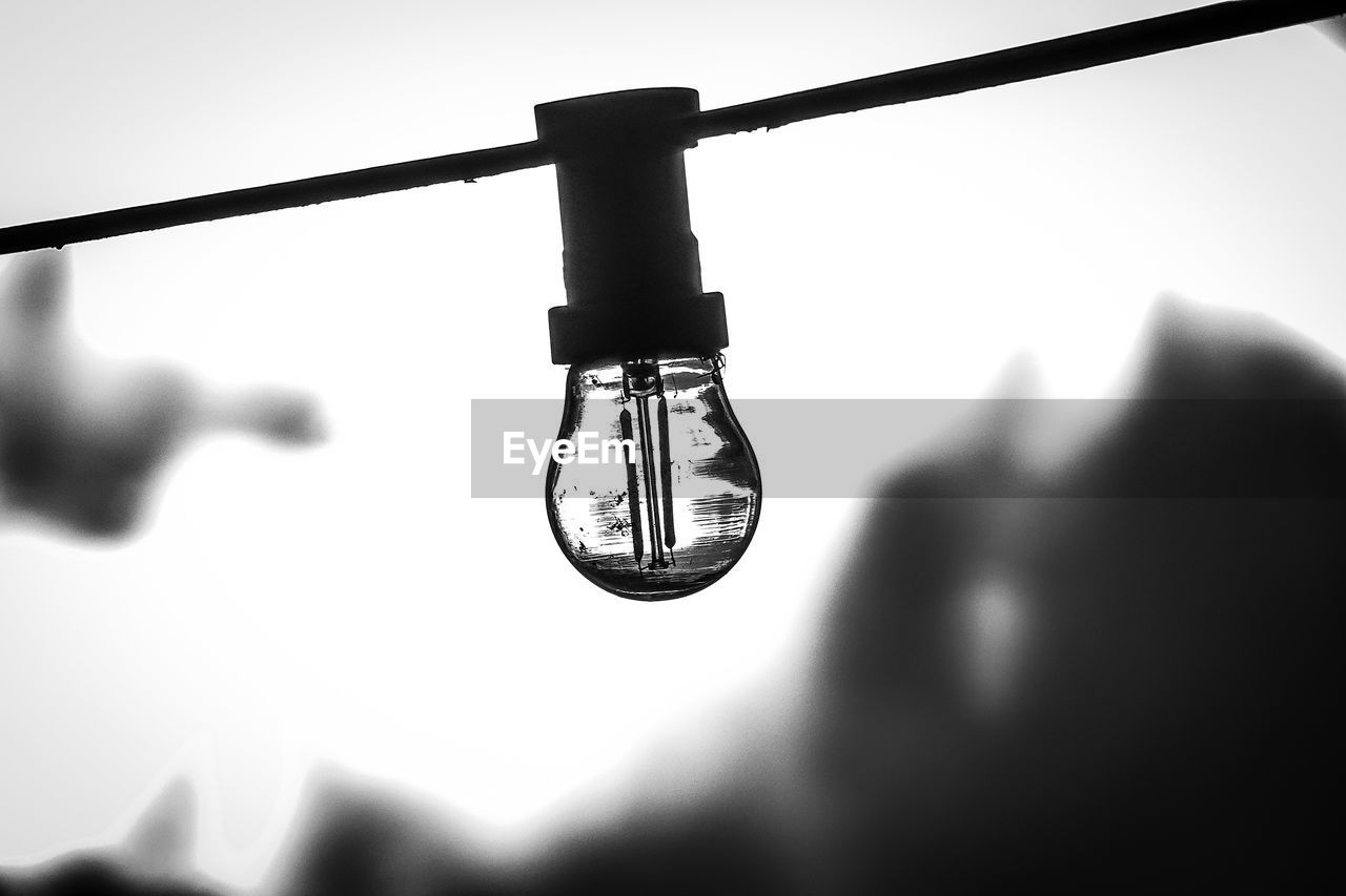 CLOSE-UP OF LIGHT BULBS AGAINST SKY