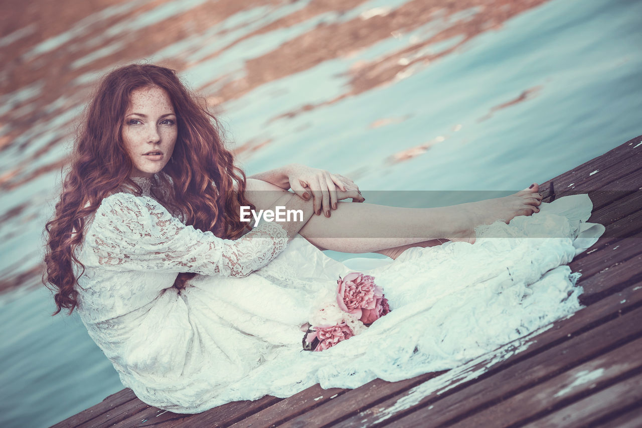 Portrait of bride sitting on pier