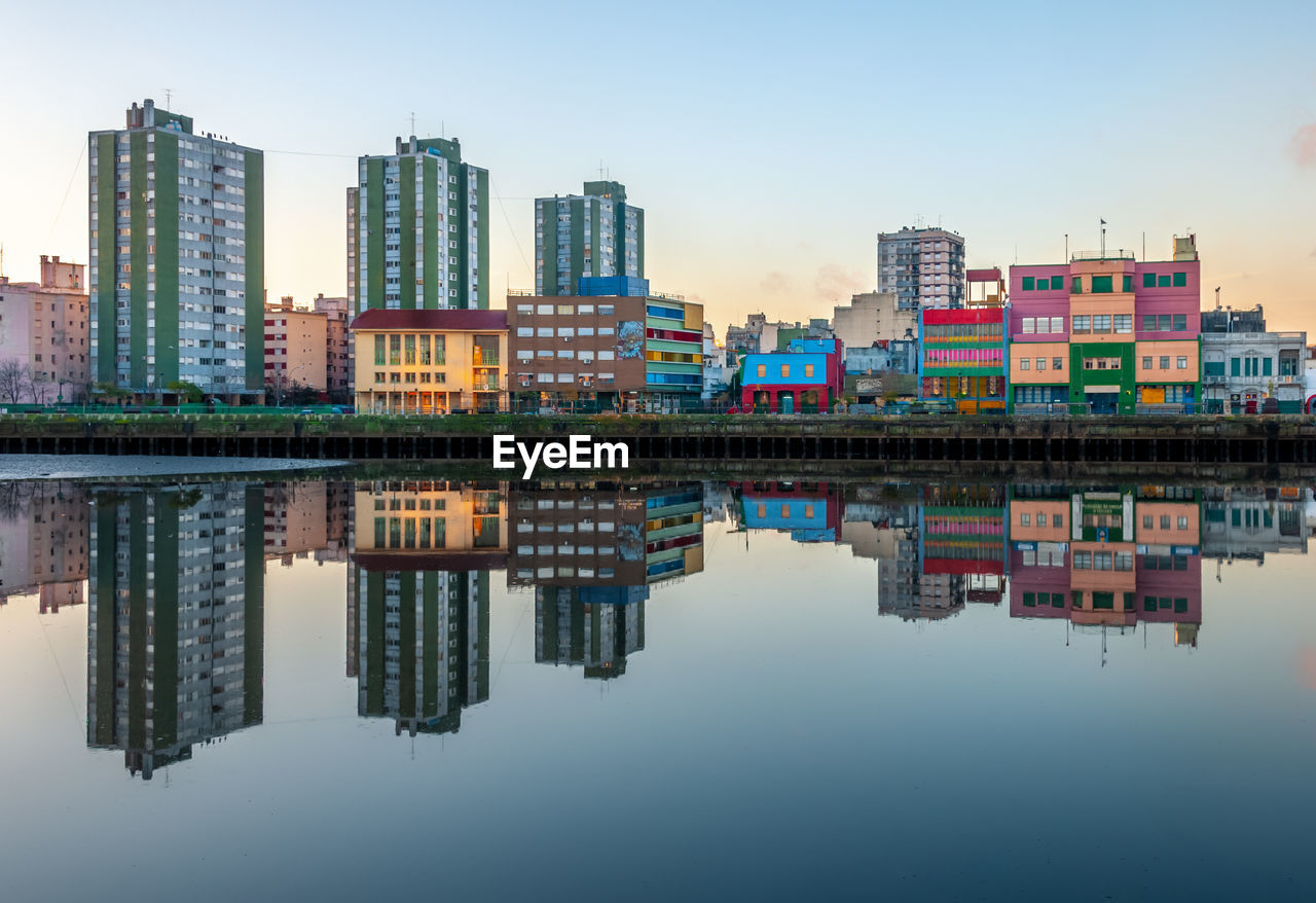 REFLECTION OF BUILDINGS IN CITY AGAINST SKY