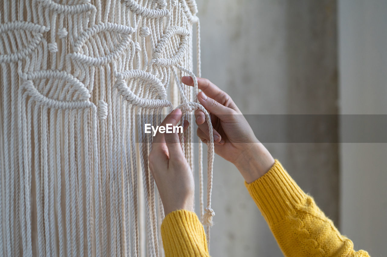 Cropped image of woman doing macrame