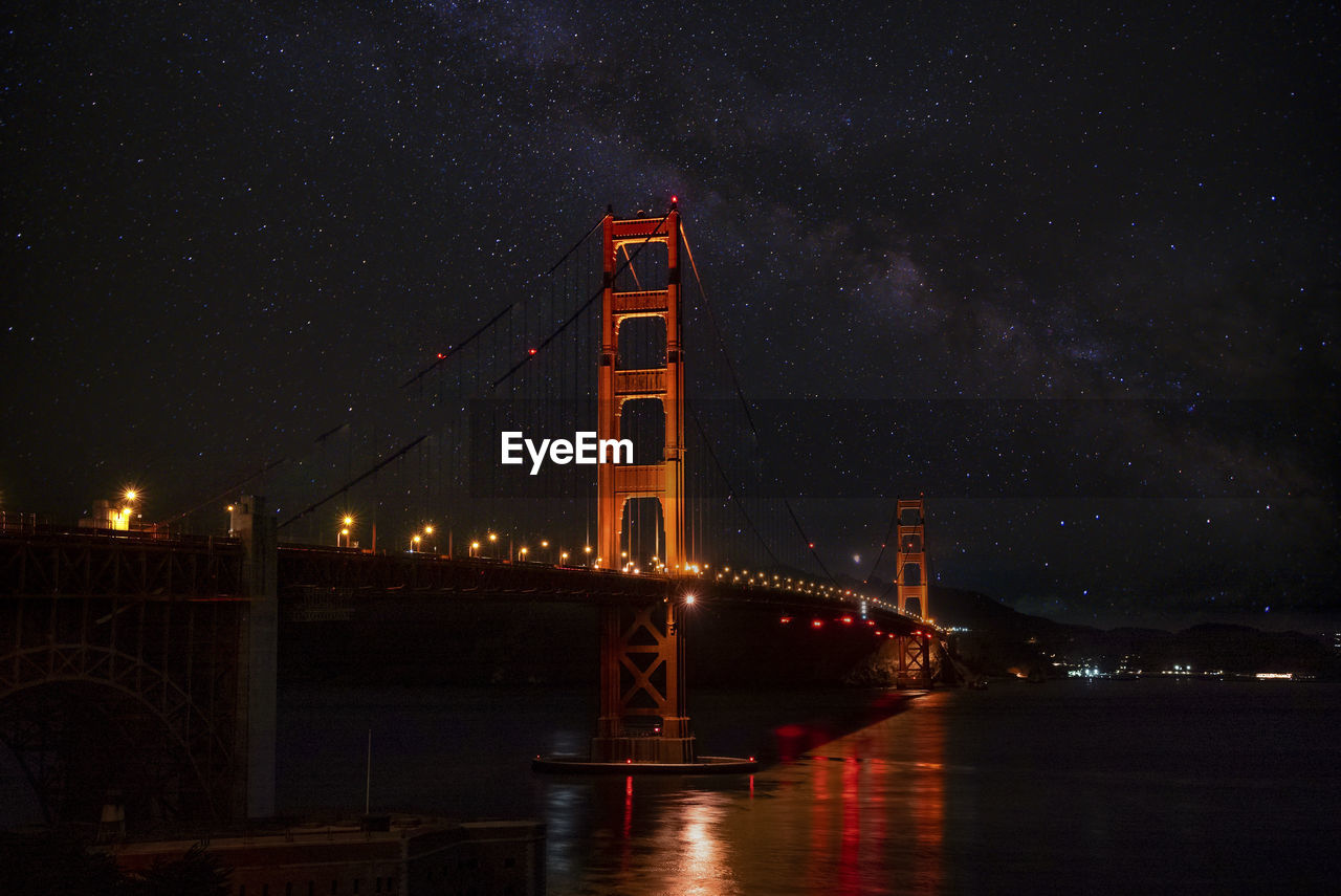 Illuminated golden gate bridge over san francisco bay with star field in the sky
